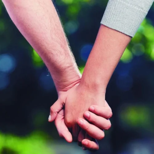 Pareja caminando de la mano feliz