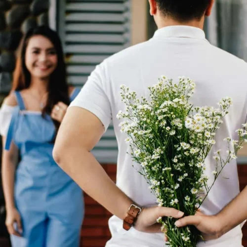 Hombre regalando flores tras encontrar el amor